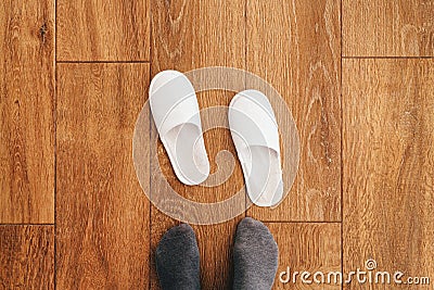 Male feet and disposable white slippers in hotel room Stock Photo