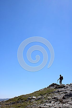 Male fellwalker on skyline on mountain footpath Stock Photo