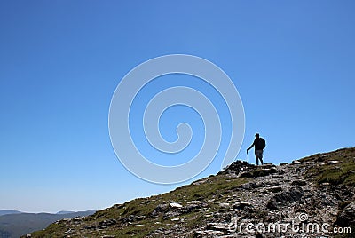 Male fellwalker on skyline on mountain footpath Stock Photo