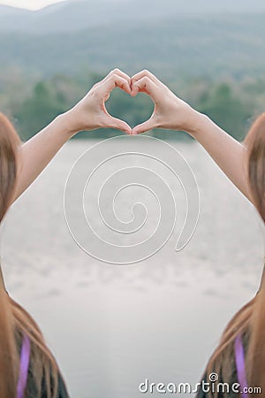 male and female couple showing their hands up to form heart symbol to show friendship love and kindness because heart is symbol of Stock Photo