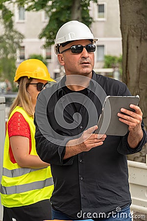 Male and female engineers at work on construction site Editorial Stock Photo