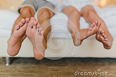 male and female feet people sitting on the bed Stock Photo