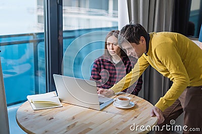 Male and female IT freelancers working with laptop and discussing results. Freelance teamwork or coworking concept Stock Photo