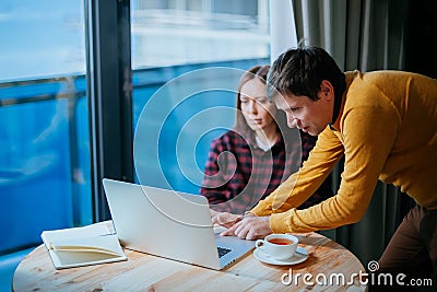 Male and female IT freelancers working with laptop and discussing results. Freelance teamwork or coworking concept Stock Photo