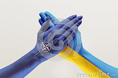 Male and female hands colored in flags of Ukraine and NATO Stock Photo