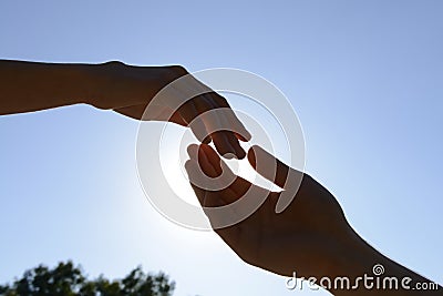 Male and female hands reaching out to each other outdoors Stock Photo