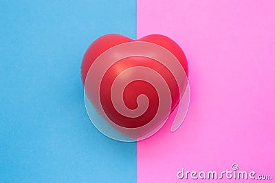 Male and female heart. Heart lies on two colors in background - blue and pink which symbolize man and woman. Medical features, uni Stock Photo