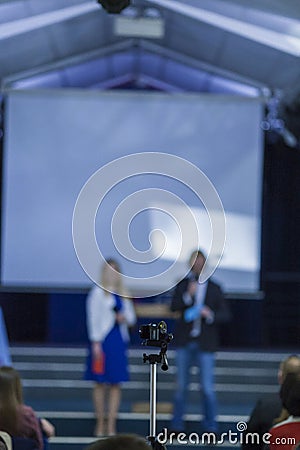 Male and Female Hosts on Stage In front of Group of People. Editorial Stock Photo