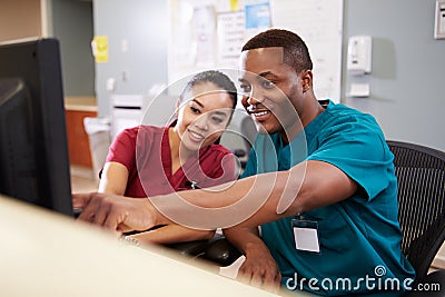 Male And Female Nurse Working At Nurses Station Stock Photo