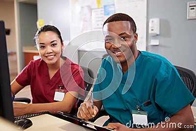 Male And Female Nurse Working At Nurses Station Stock Photo