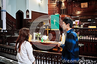 A male and female person having a religious conversation in front of the altar of the St. James United Church in Montreal, Quebec Editorial Stock Photo
