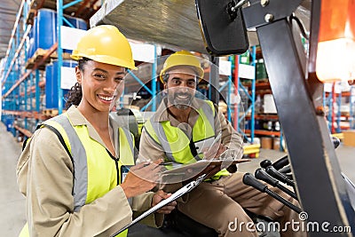 Male and female staff discussing over clipboard in warehouse Stock Photo