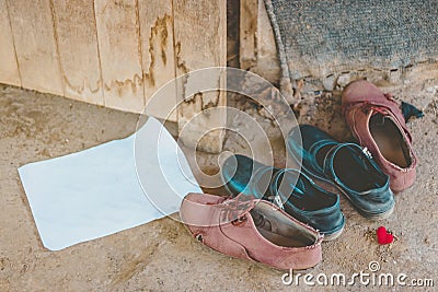 Male and female students take off their shoes at the front entrance of an abandoned cottage. Stock Photo