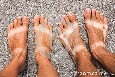 Male and female tanned feet. Stock Photo