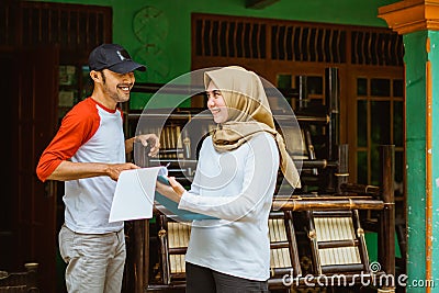 male and female veiled entrepreneurs use list paper and clipboard Stock Photo