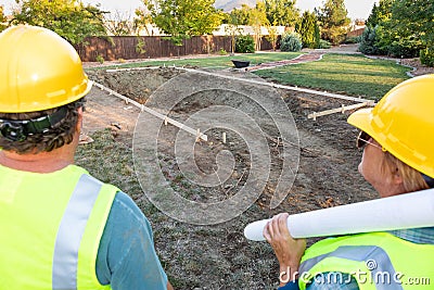 Male and Female Workers Overlooking Pool Construction Site Stock Photo