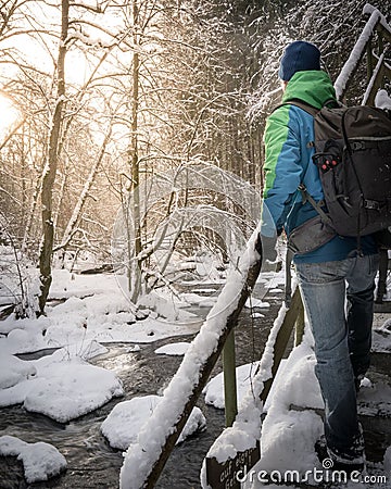 Male figure standing on the snow covered stairs in the forest, exploring Stock Photo