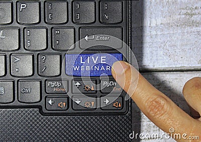 Male finger pressing blue key labeled with LIVE WEBINAR. Stock Photo