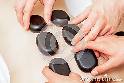 Male four hands laying stones on female back Stock Photo