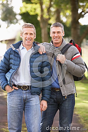 Male Friends Walking In Autumn Park Stock Photo