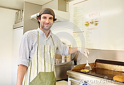 Male fry cook frying a fresh hamburger patty with cheese Stock Photo