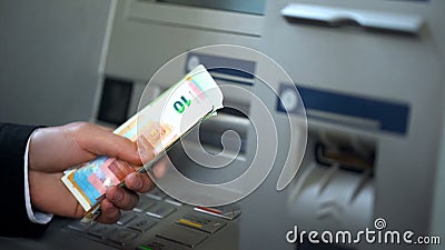 Male getting euros from automatic teller machine, cash withdrawing, banking Stock Photo