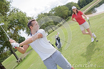 Male golf instructor teaching female golf player Stock Photo