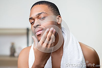 male grooming skin care african man touching face Stock Photo