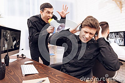 A male guard screams at another guard. Stock Photo