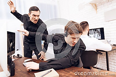 A male guard screams at another guard. Stock Photo