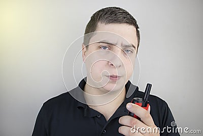 A male guard talking on a walkie talkie with his partner. A policeman takes up the challenge of public safety. Safety and Security Stock Photo