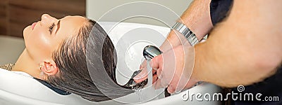 Hairdresser rinses hair of woman Stock Photo