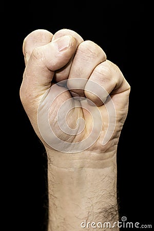 Male hand clenched into a fist on the black background Stock Photo