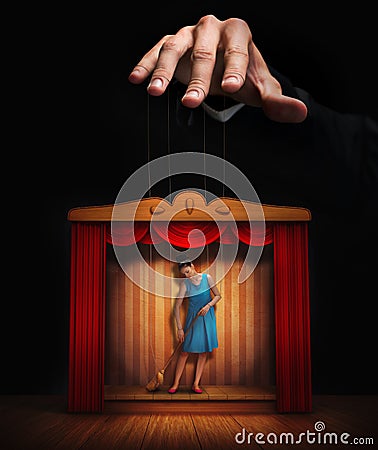 Male hand controlling a small woman puppet Stock Photo