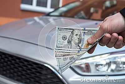 Male hand dollar, take money on car background Stock Photo