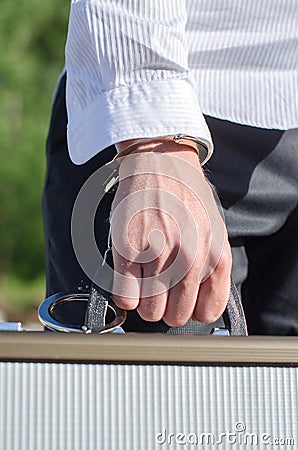 Male hand enchained to suitcase Stock Photo