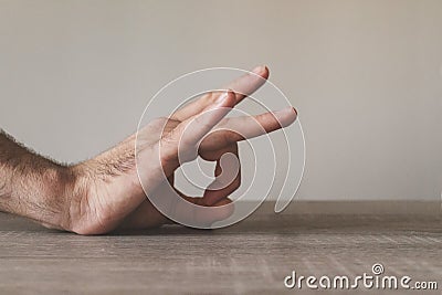 Male hand flicking on a wooden table Stock Photo