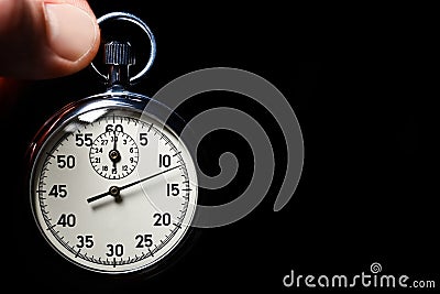 Male hand hold the analog stopwatch on a black background, close-up, isolate, copy space Stock Photo