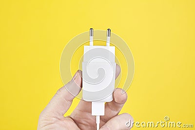 Male hand holding ac dc adapters smartphone recharge supply. Close up Stock Photo