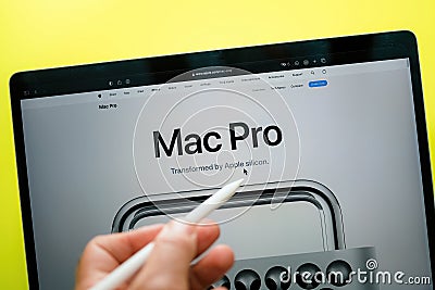 Male hand holding Apple Pencil pointing on the website to the Mac pro with Apple Editorial Stock Photo