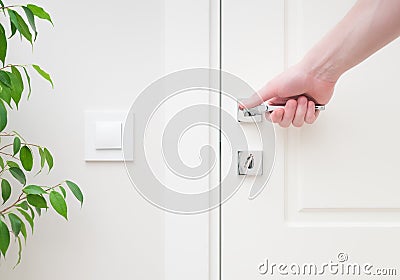 Male hand holding modern door handle. Close-up elements of the interior of the apartmen Stock Photo