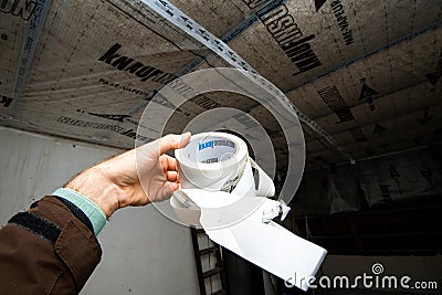 Male hand holding new Knauf High performance adhesive for bonding overlaps of Editorial Stock Photo