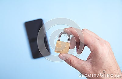 Male hand holding padlock. Smartphone security Stock Photo
