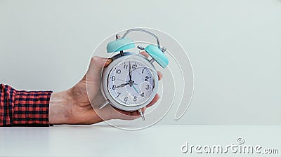 Retro styled white alarm clock in manâ€™s hand, Stock Photo