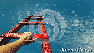 Development Attainment Motivation Career Growth Concept. Mans Hand Reaching For Red Ladder Leading To A Blue Sky Stock Photo