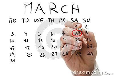 Male hand marking on calendar the date of March 8 Stock Photo