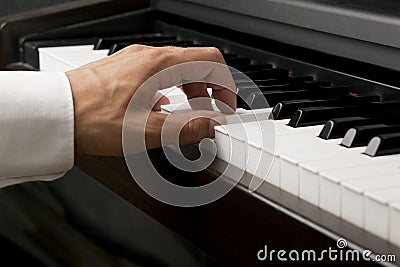 Male hand on a piano Stock Photo