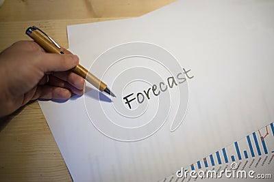 Male hand pointing at a Forecast document printed on a white sheet of paper during a business meeting Stock Photo