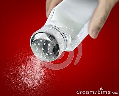 Male hand pouring salt from a salt shaker Stock Photo