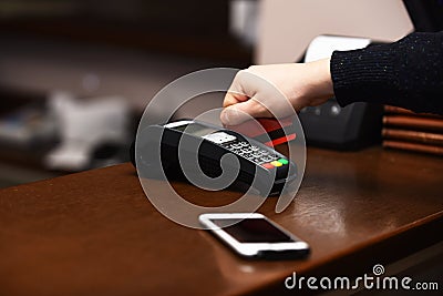 Male hand puts bankcard into reader on defocused background Stock Photo